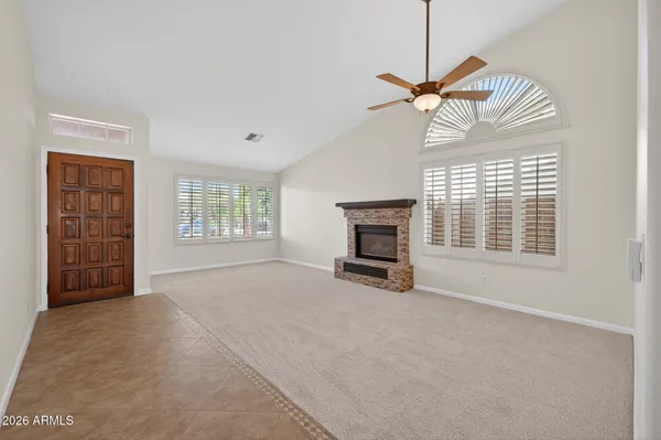 a view of an empty room with a fireplace and a window