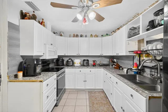a kitchen with granite countertop a sink a stove and cabinets