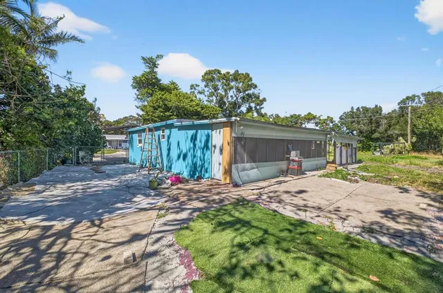 a backyard of a house with table and chairs a barbeque with wooden fence