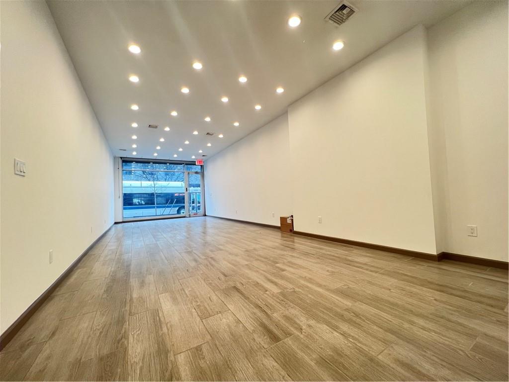 an empty room with wooden floor and entrance