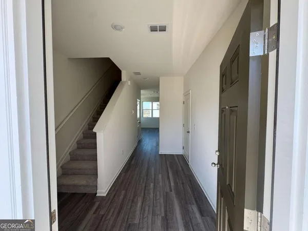 a view of a hallway with wooden floor and staircase