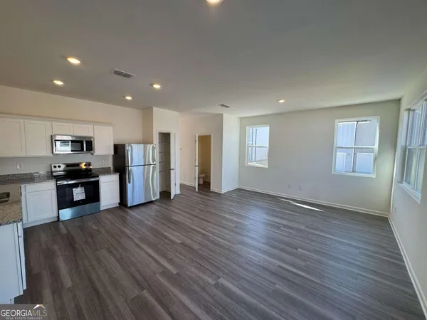 a view of kitchen with stove and refrigerator