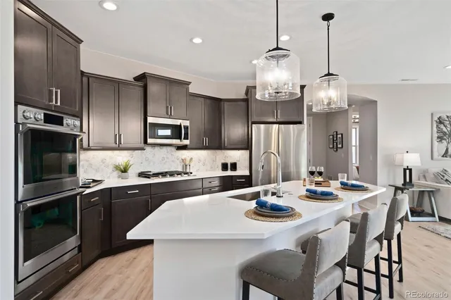 a kitchen with refrigerator cabinets dining table and chairs
