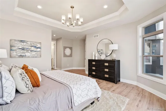 a bedroom with a bed and a chandelier