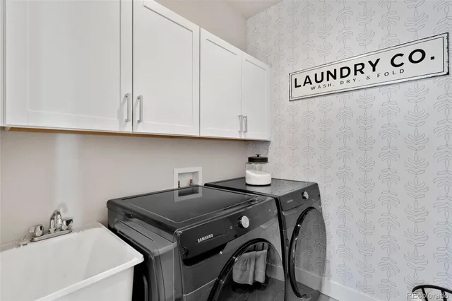 a utility room with sink dryer and washer