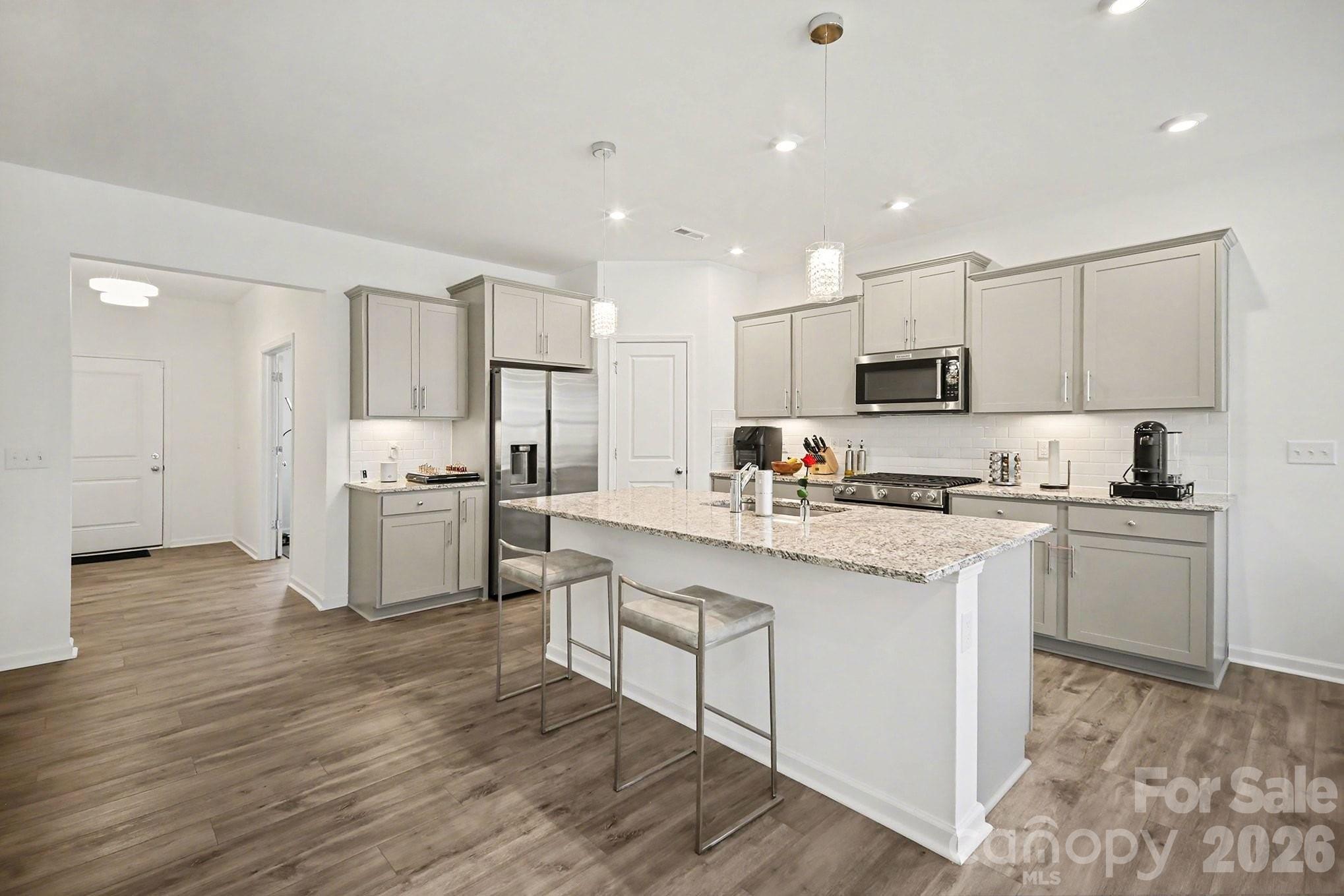 11122 Glasden Road Charlotte, NC 28278 - Photo 12 of 32 a kitchen with white cabinets and stainless steel appliances