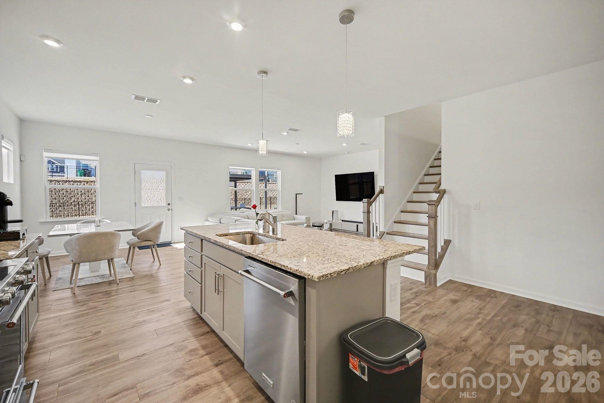 11122 Glasden Road Charlotte, NC 28278 - Photo 14 of 32 a kitchen with a stove a refrigerator a dining table and chairs with wooden floor