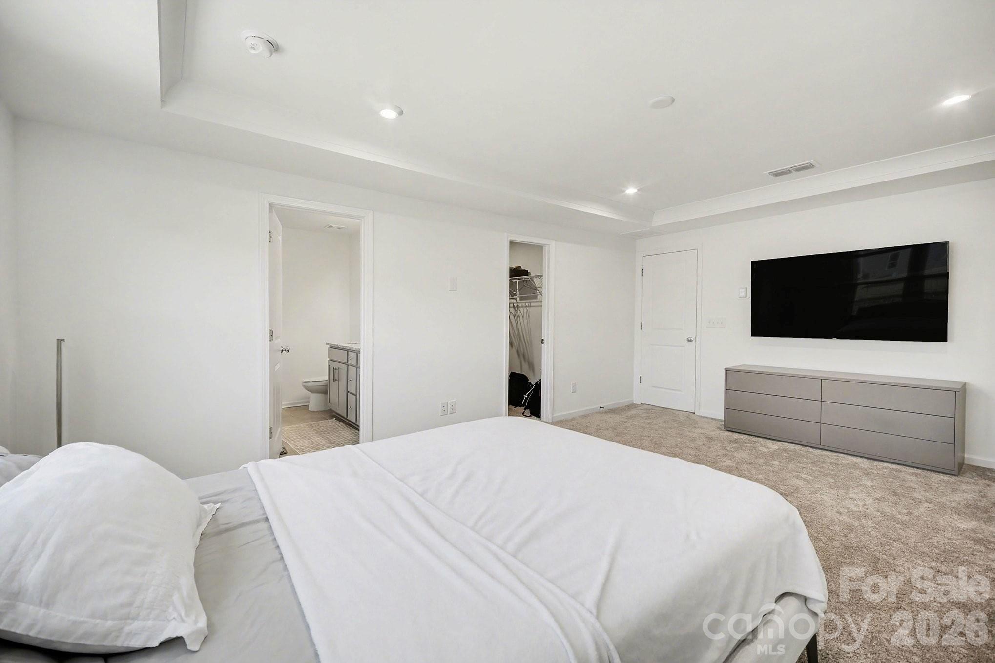 11122 Glasden Road Charlotte, NC 28278 - Photo 20 of 32 a bedroom with a bed and a flat screen tv