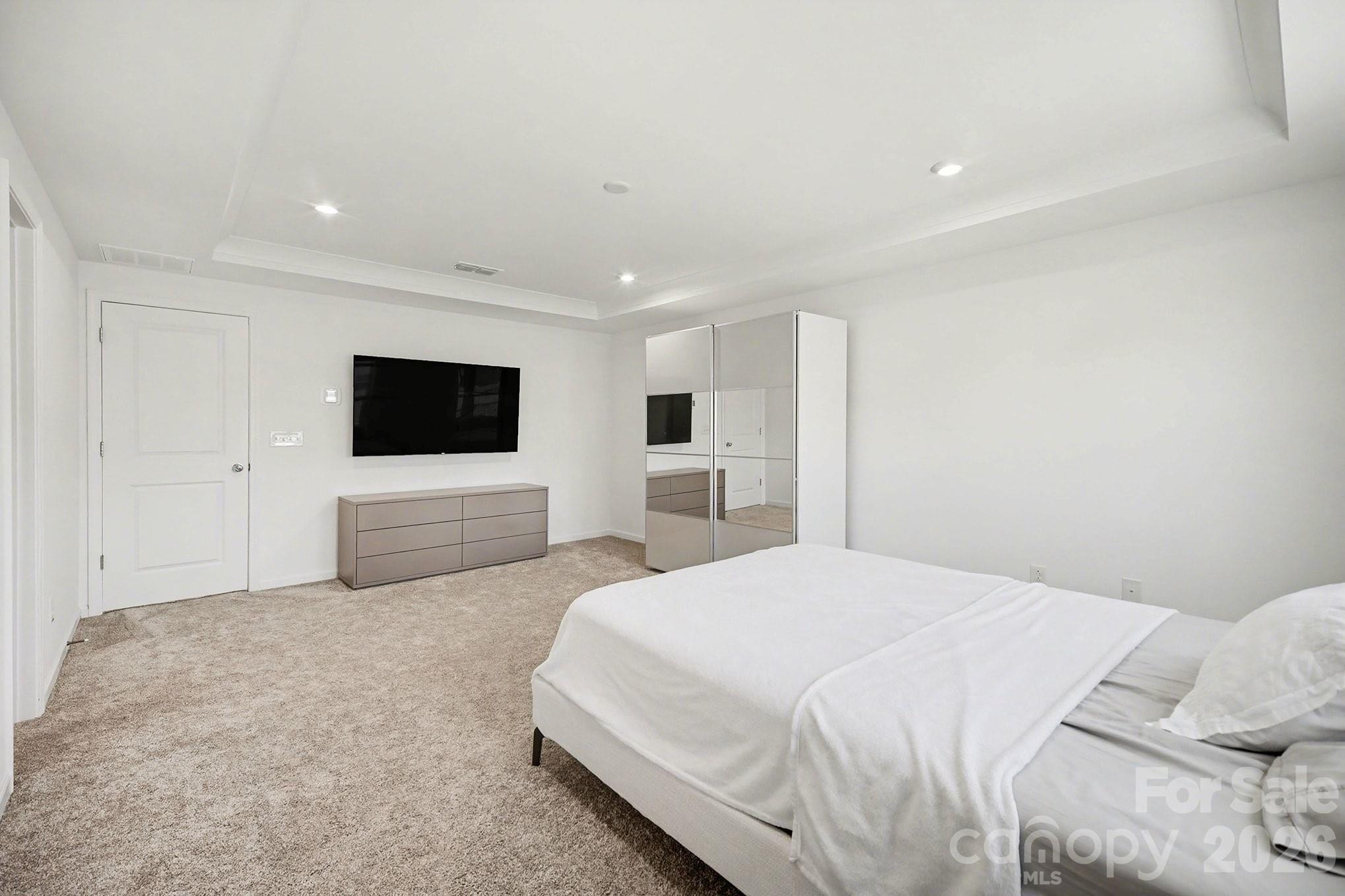 11122 Glasden Road Charlotte, NC 28278 - Photo 21 of 32 a spacious bedroom with a bed and a flat screen tv