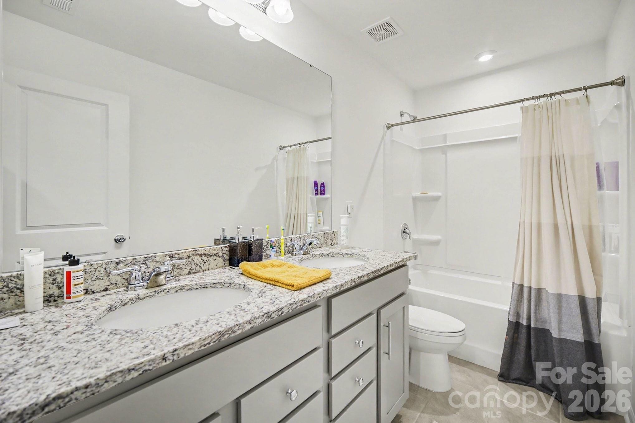 11122 Glasden Road Charlotte, NC 28278 - Photo 24 of 32 a bathroom with a granite countertop sink a toilet and shower