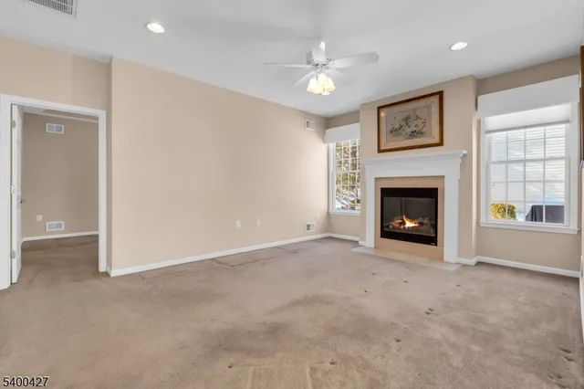 a view of an empty room with window and fireplace