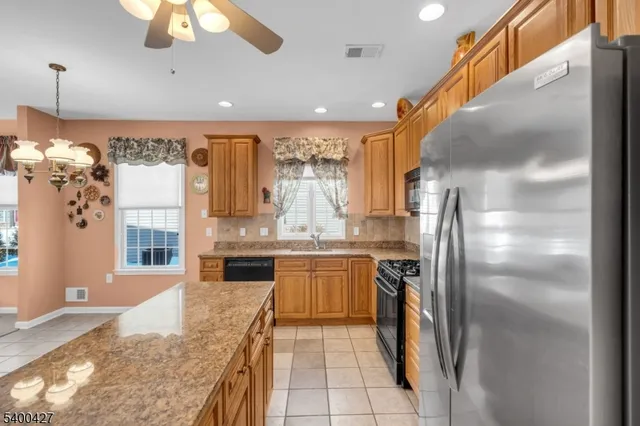a kitchen with stainless steel appliances granite countertop a refrigerator a oven a sink and dishwasher