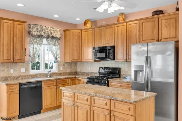 a kitchen with stainless steel appliances granite countertop a refrigerator a stove top oven a sink and dishwasher