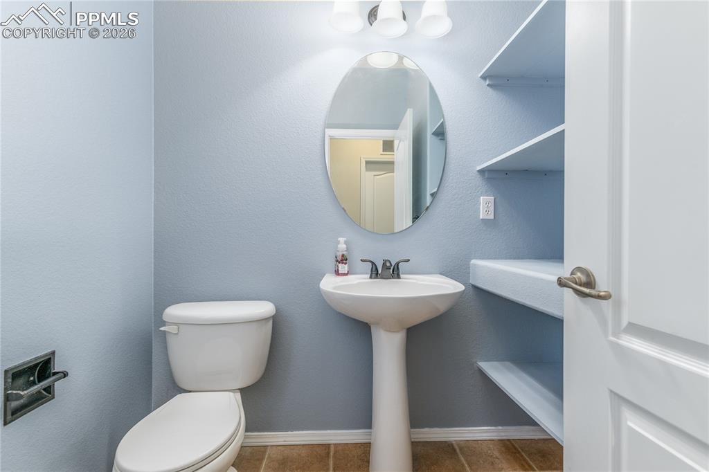 6432 Crystal Mountain Road Colorado Springs, CO 80923 - Photo 13 of 31 a bathroom with a toilet sink and mirror
