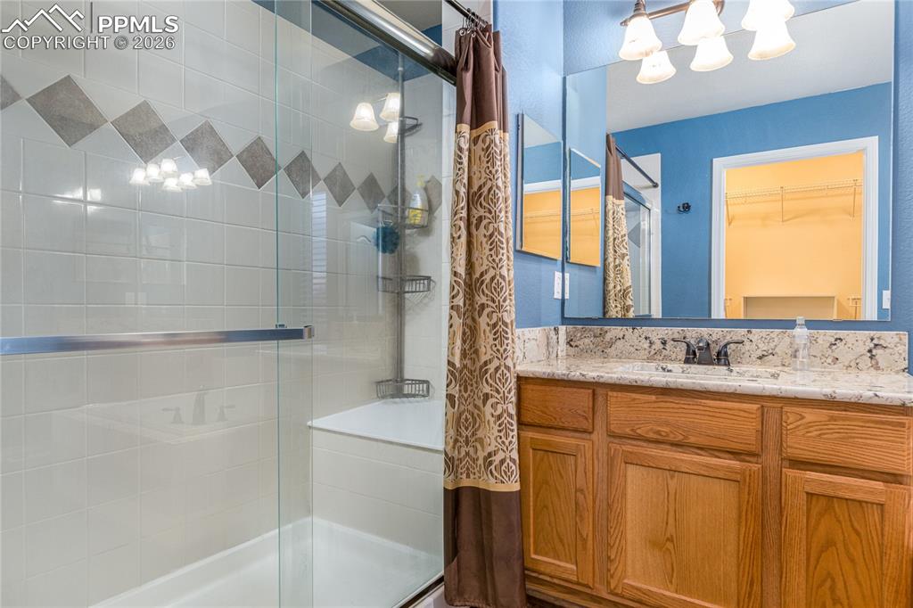 6432 Crystal Mountain Road Colorado Springs, CO 80923 - Photo 18 of 31 a bathroom with a granite countertop sink a toilet and bathtub