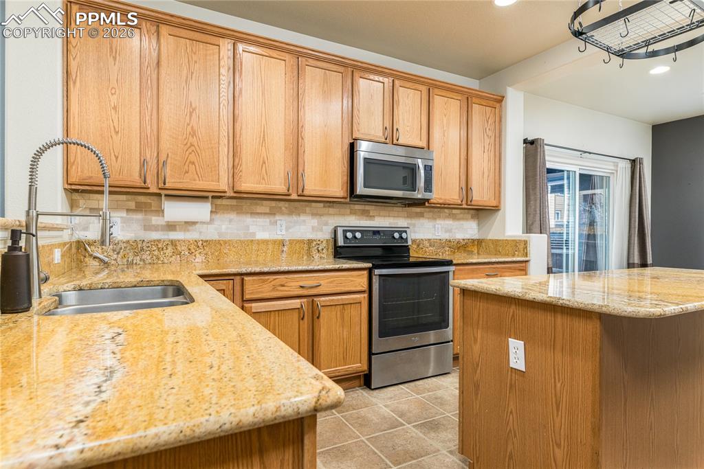 6432 Crystal Mountain Road Colorado Springs, CO 80923 - Photo 4 of 31 a kitchen with granite countertop a stove top oven sink and cabinets