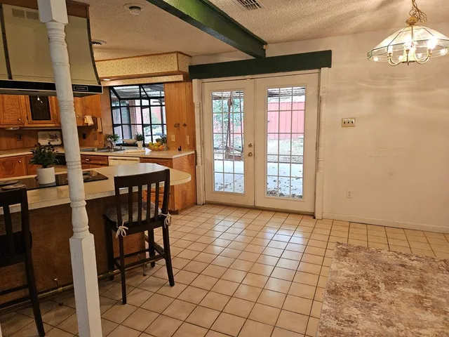 a dining hall with a sink a counter top space and stainless steel appliances