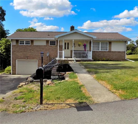 a front view of house with yard outdoor seating and barbeque oven