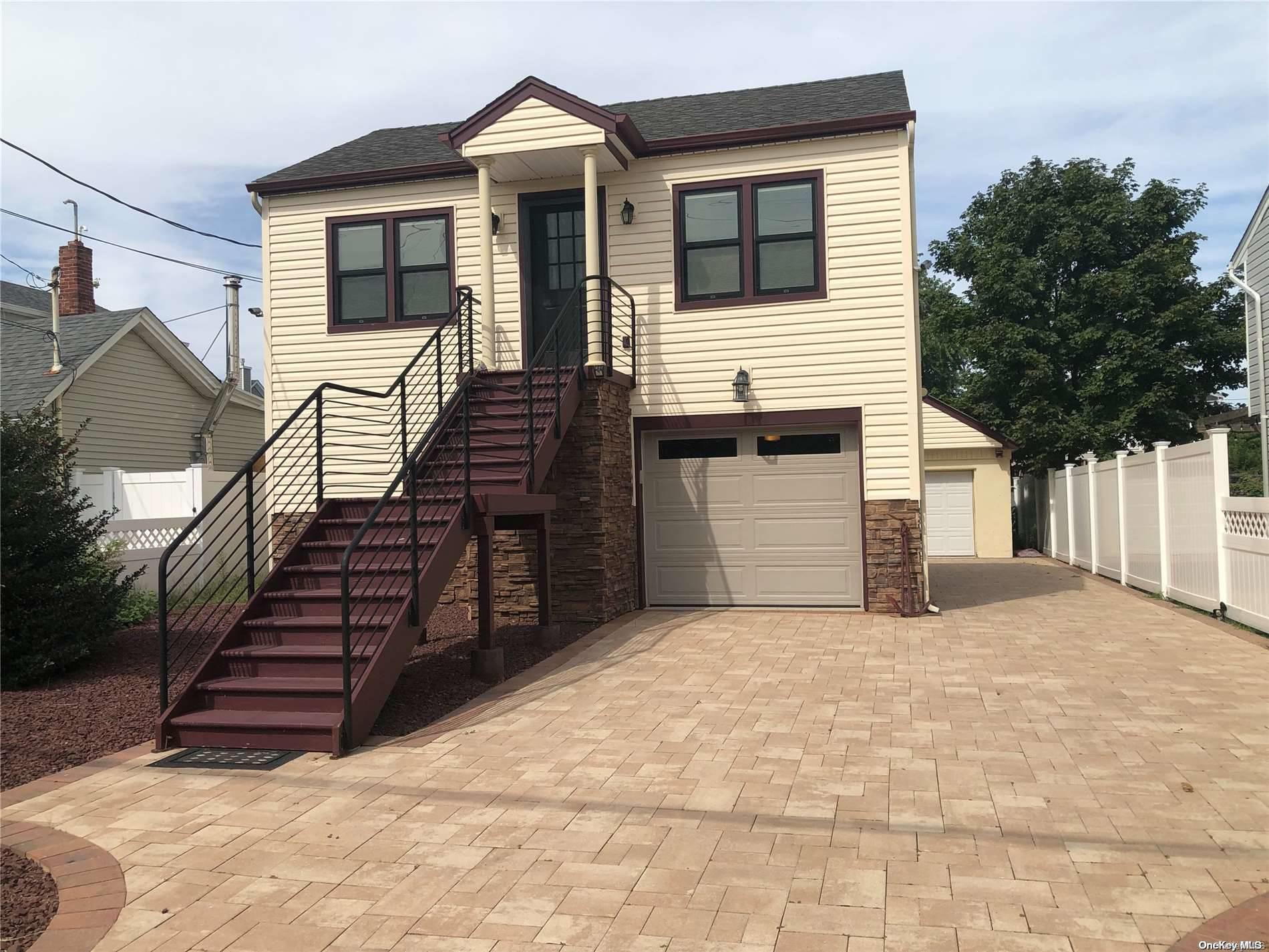 a view of a house with wooden stairs and a large tree