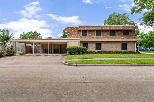 a view of a house with a small yard and palm trees