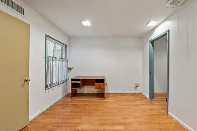 an empty room with windows and closet