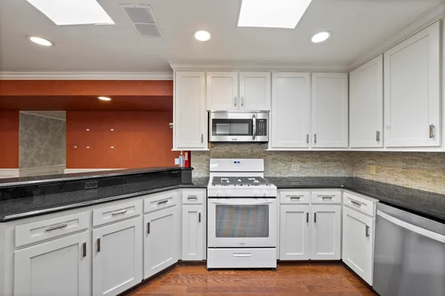 a kitchen with white cabinets and white appliances