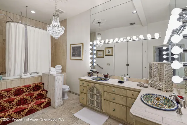 a bedroom with a bed and dresser with mirror