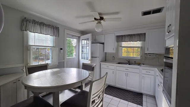 a kitchen with a table chairs sink and cabinets