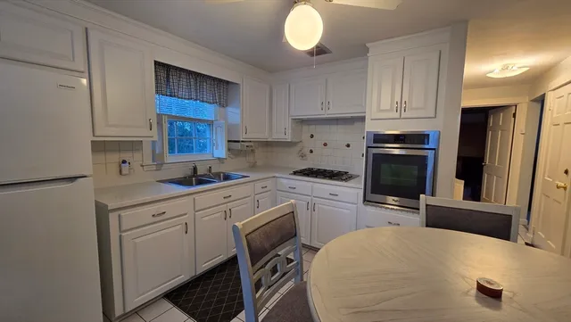 a kitchen with granite countertop a sink stove and refrigerator