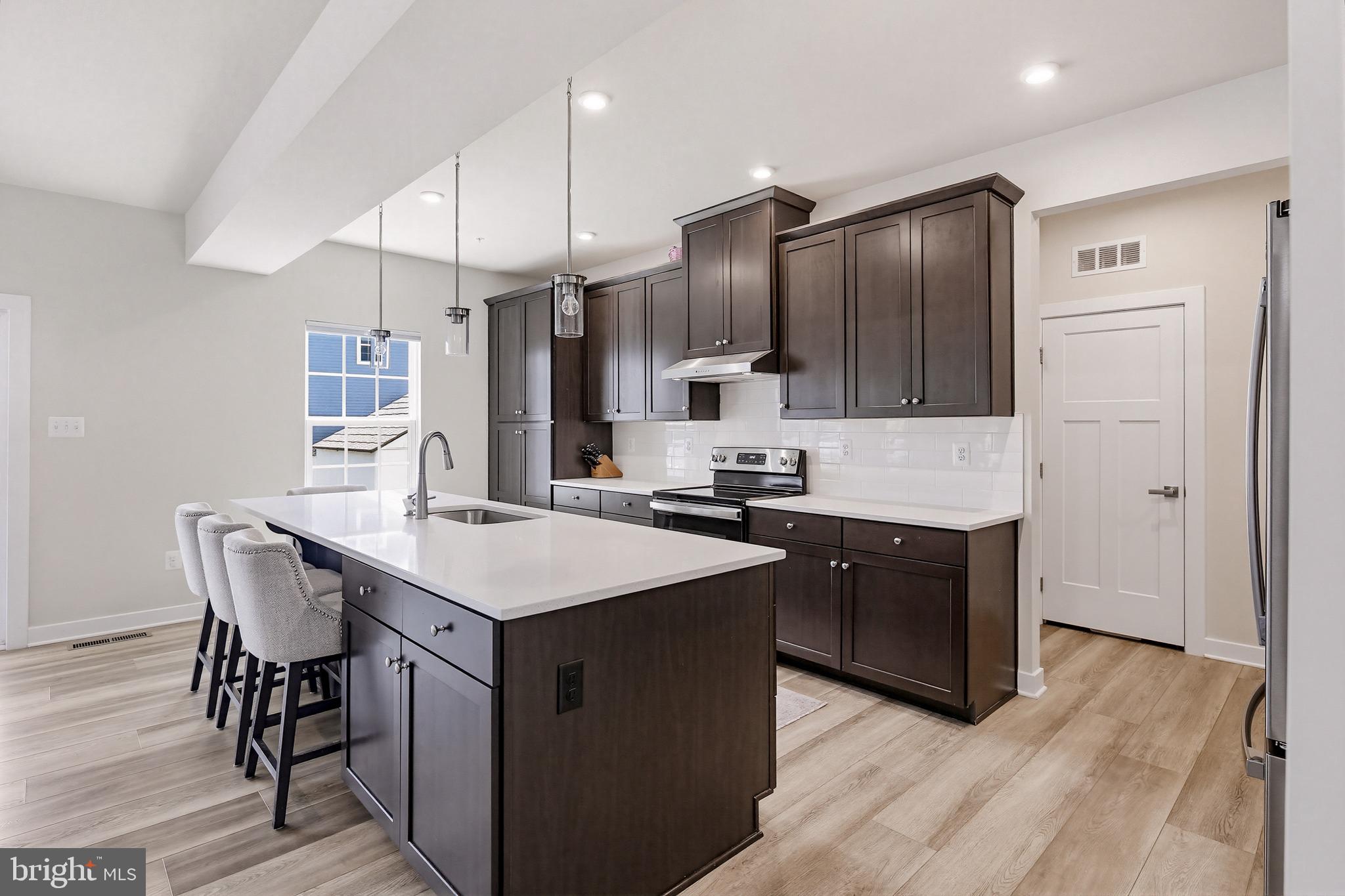 3172 Dodder Way Odenton, MD 21113 - Photo 13 of 59 a kitchen with stainless steel appliances kitchen island granite countertop a sink a stove a refrigerator and island with wooden floor