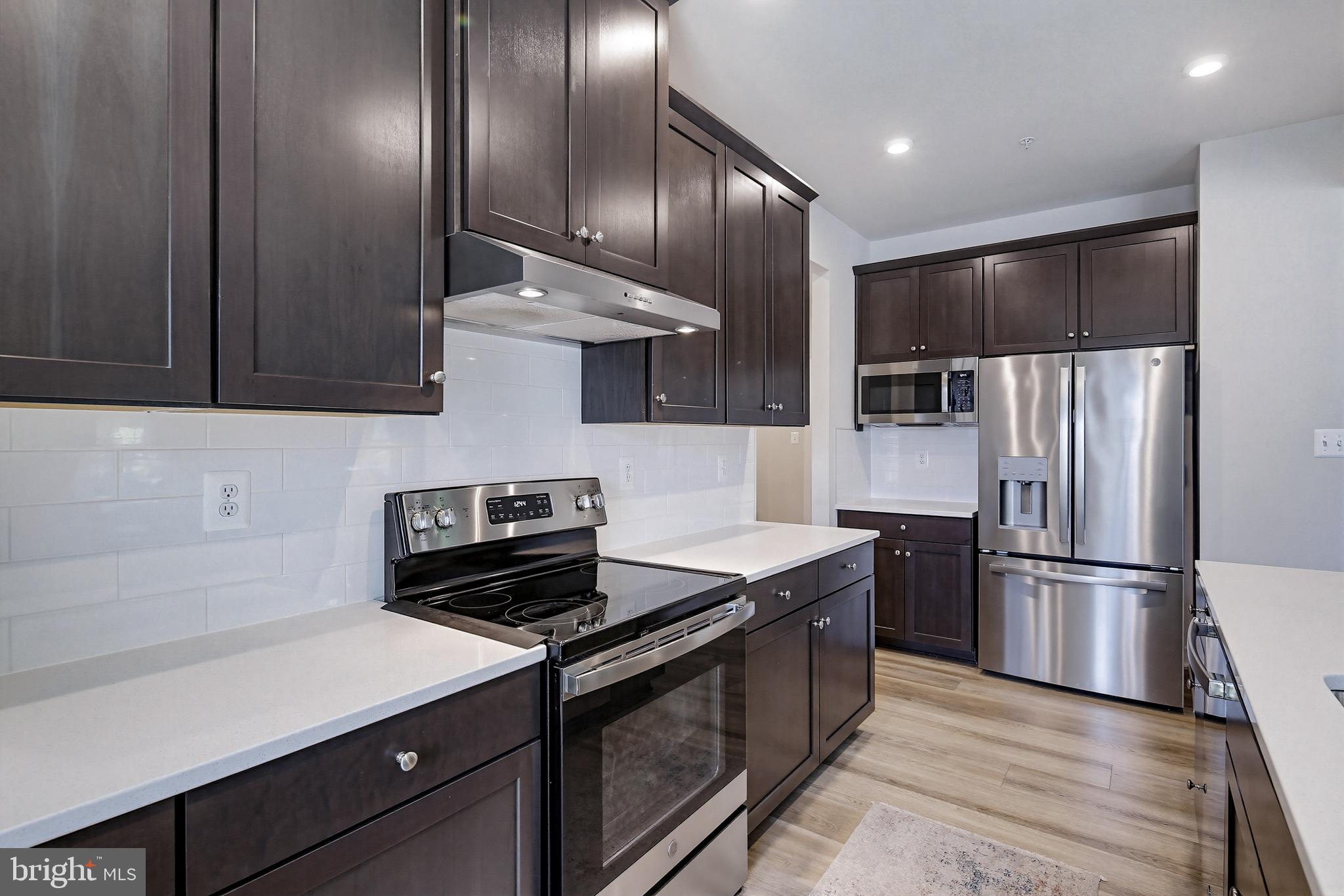 3172 Dodder Way Odenton, MD 21113 - Photo 17 of 59 a kitchen with kitchen island granite countertop stainless steel appliances and wooden cabinets