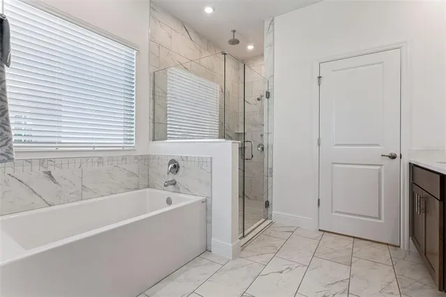 a spacious bathroom with a bathtub and a shower
