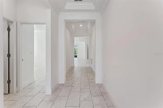a view of a hallway with wooden floor and a bathroom
