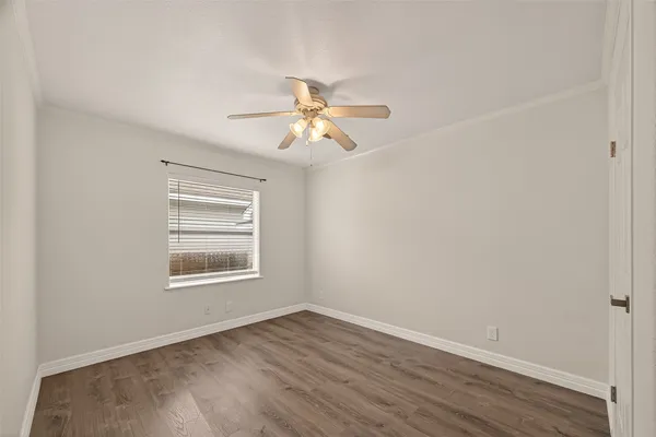 an empty room with a window and a fan