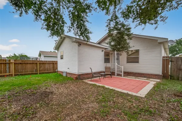 a view of a backyard with table and chairs and wooden fence