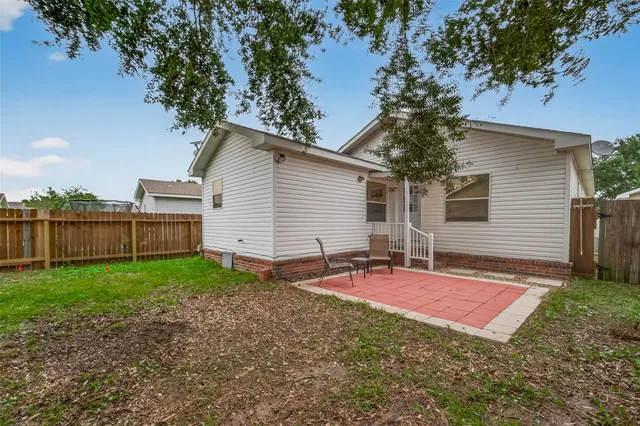 a view of a backyard with table and chairs and wooden fence