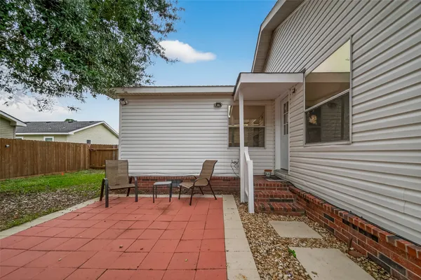 a backyard of a house with wooden fence and large trees