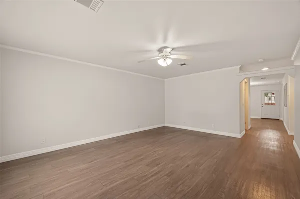 a view of an empty room with wooden floor
