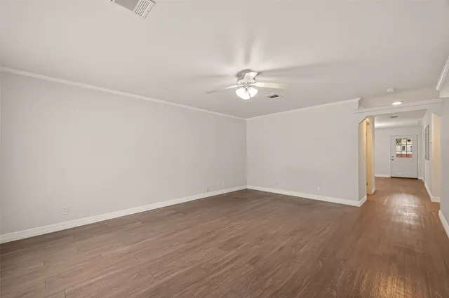a view of an empty room with wooden floor