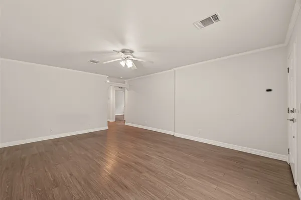 a view of an empty room with wooden floor