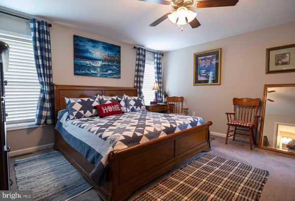 a bed sitting in a bedroom next to a window with a chandelier and dresser