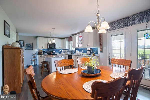 a kitchen with granite countertop a refrigerator a stove top oven a sink dishwasher and white cabinets with wooden floor