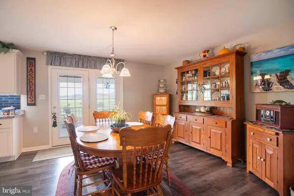 a dining room with furniture a chandelier and wooden floor