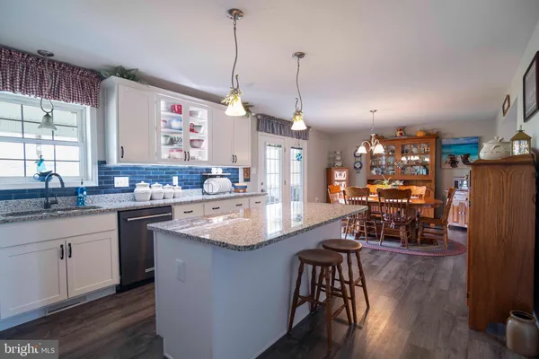 a kitchen with stainless steel appliances granite countertop a sink a stove and chairs