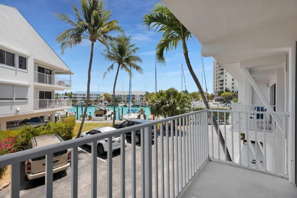a view of balcony with wooden floor and palm trees