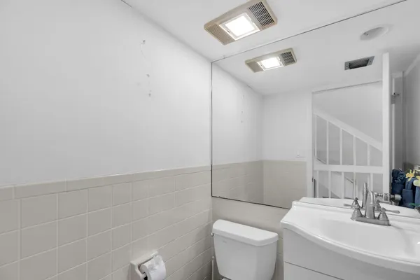 a bathroom with a toilet a sink and mirror