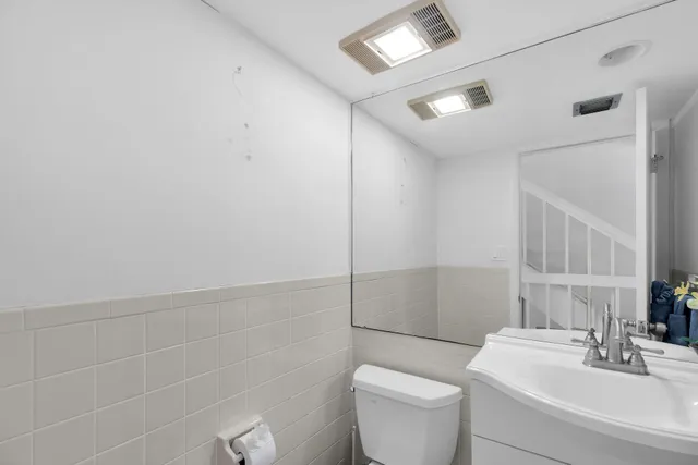 a bathroom with a toilet a sink and mirror