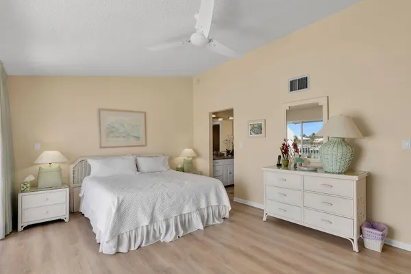 a bedroom with a bed and a lamp on dresser