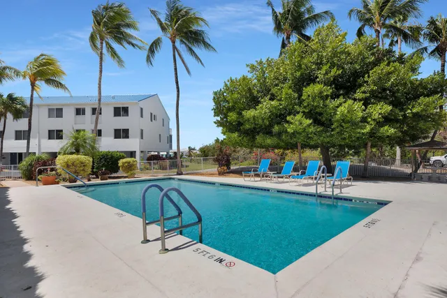 a view of swimming pool with outdoor seating and plants