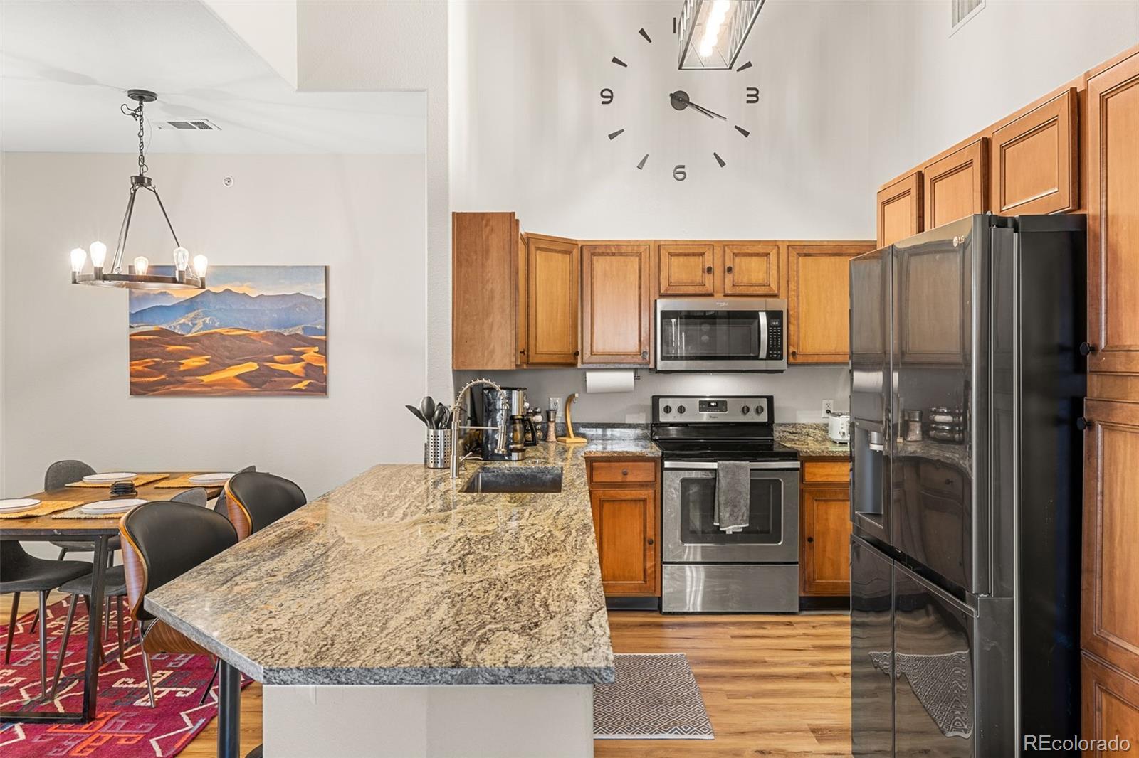 8073 West 51st Place, Unit 303 Arvada, CO 80002 - Photo 11 of 48 a kitchen with stainless steel appliances granite countertop a stove refrigerator and a microwave
